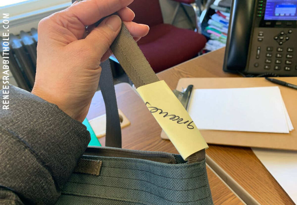 Close up of post-it-note pinned to purse strap